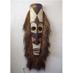 Tribal Art, TIKI MASK, a monumental mask of carved and painted wood, surrounded by woven grass,...