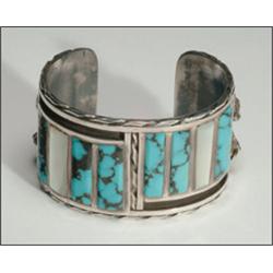 2 sterling silver open bangles, the first in a Zuni style formed as a thick cuff channel inlaid...