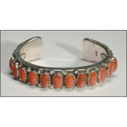 Navajo sterling silver open bangle, formed of an thick ingot band set with a row of 12 oval cor...