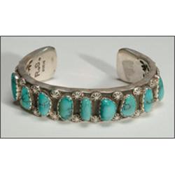 Navajo sterling silver open bangle, formed of a thick ingot band set with 9 irregular turquoise...