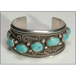 Navajo sterling silver open bangle, set with 7 oval turquoise cabochons in serrated bezels on a...