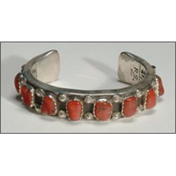 Navajo sterling silver open bangle, formed of a thick ingot band set with 8 irregular coral cab...