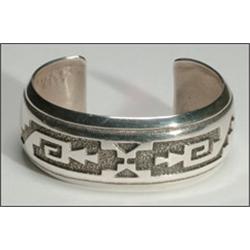 Navajo sterling silver open bangle, formed as a concave flat ingot band with incised decoration...