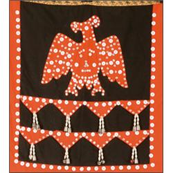 A Northwest Coast cloth apron decorated with a buttoned and appliqued red cloth Thunderbird, with...