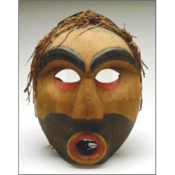 A Northwest Coast Nootka carved and painted wood mask, with cedar bark attachment, 14" - 35.6 cm....