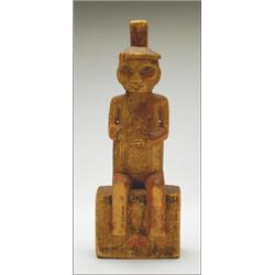 A Northwest Coast carved and painted wood figure wearing a potlatch hat, sitting on a decorated b...
