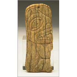A Northwest Coast bone pendant carved in relief with a crouching bear, 4.3" - 10.8 cm., See ill...