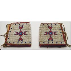 A pair of Plains hide cuffs, decorated in beaded geometric motifs on a white ground,, 5.5" - 14...