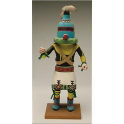 A HOPI POLYCHROME WOOD KACHINA DOLL, the standing figure with bent knees, a cylindrical nose and...
