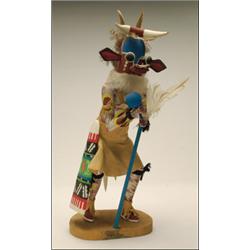 A HOPI POLYCHROME WOOD KACHINA DOLL, representing the Cow Kachina, the figure wearing a hide kilt...