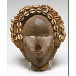 Dan Mask, the almond shaped face with bulbous forehead and protruding mouth, ringed with a fabr...