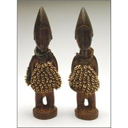 Pair of Yoruba Ibeji Figures, of males, each wearing a cowrie cape and a bead belt, the shoulde...