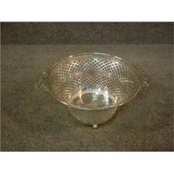 Une corbeille circulaire ajourée en argent sur des pieds boules....