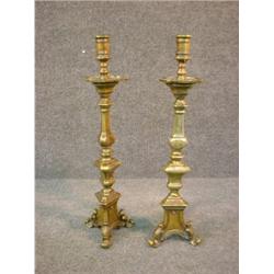 Une paire de bougeoirs du 18e Siècle en bronze, sur des bases tripodes....