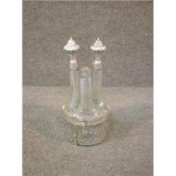 Un ensemble de 3 carafes en verre taillé à montures d'argent sur un support ajouré à décor de scè...