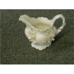 Un crémier en porcelaine blanche de Coalport, vers 1820, à décor moulé de fleurs et de coquilles...
