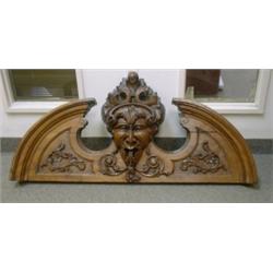 Un arc brisé du 19e Siècle en bois sculpté d'une tête de satyre et de feuillage....