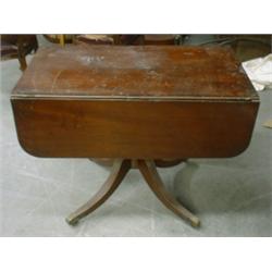 Une table du 19e Siècle en acajou à double abattant, renfermant un tiroir en ceinture et reposant...