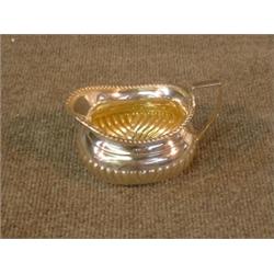 Un crémier en argent lobé, poinçons de Sheffield, 1928....