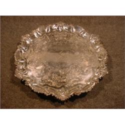 Un plateau circulaire d'époque George III à décor gravé de coquilles, porte un blason et une dédi...