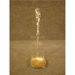 Une louche en argent de Gorham, le bol en forme de coquille, le manche orné sur toute sa longeuer...