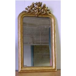 Un miroir en bois doré d'époque Louis-Philippe, vers 1840, le fronton orné de deux chérubins flan...