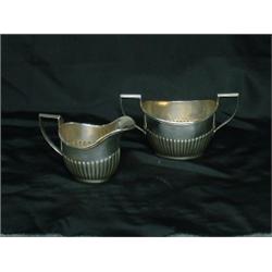 Un crémier et un sucrier assorti en argent de Birks à décor lobé....