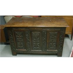 Un coffre en chêne du 18e Siècle, la façade sculptée de panneaux floraux, sur des pieds droits....