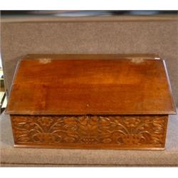 Une boîte à bible ancienne en chêne, le couvercle en pente au-dessus d'un bandeau sculpté de fleu...