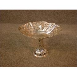 Une corbeille ovale sur pied américaine en argent, les parois ajourées ornées de fleurs....