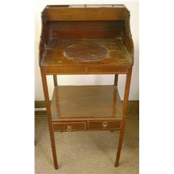 Un meuble de toilette en acajou, vers 1830, le plateau évidé sous trois casiers couverts (manque...