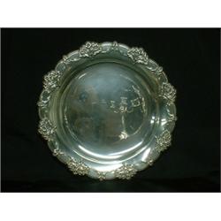 Une assiette en argent, le marli orné de fleurs, par International Sterling....