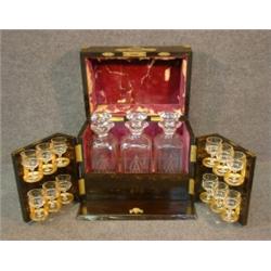 Une cave à liqueurs en palissandre à montures de laiton doré, vers 1900, renfermant sa garniture...