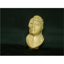Un pommeau de canne en ivoire sculpté d'une vanité.  An ivory cane grip carved with a "vanity". $...