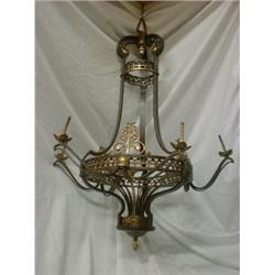 Un lustre en fer forgé et bronze doré à six branches de lumière....