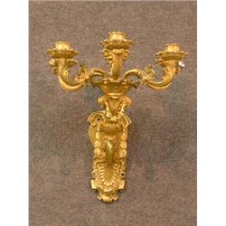 Une paire d'appliques de style Louis XVI en bronze doré à six branches de lumière à décor de guir...