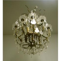 Un lustre de style Louis XV en bronze et métal doré à 5 branches de lumière, orné de pendeloques...