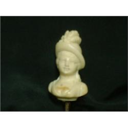 Un pommeau de canne en ivoire représentant une jeune élégante en buste....