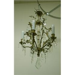 Un lustre de style Louis XV en bronze doré à 5 branches de lumière à décor de pendeloques de cris...