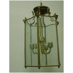 Une lanterne hexagonale en laiton supportant des panneaux de verre biseauté....