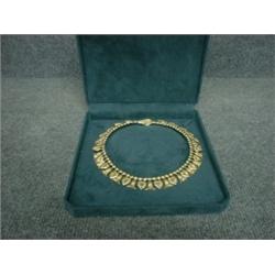 Un collier rigide en or jaune 17kt à décor de fleurs et de feuilles de lotus....