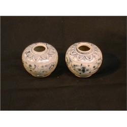 Une paire de petits pots globulaires à décor de fleurs à cinq pétales et de branchage sous une fr...