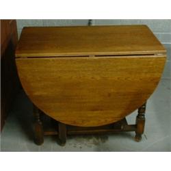 Une table en chêne à double abattant, sur des pieds balustres réunis par des entretoises....