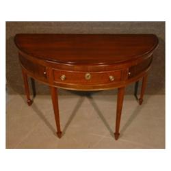 Une console edwardienne en demi-lune en acajou munie d'un tiroir central flanqué de deux panneaux...