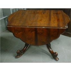 Une table à double abattant victorienne en palissandre, le plateau chantourné sur quatre pieds en...