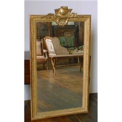 Un miroir en bois doré de style Louis XV d'èpoque Napoléon III, le fronton sculpté de feuilles de...