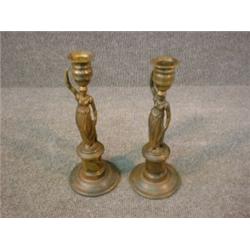 Une paire de bougeoirs en bronze patiné de style Empire en forme de jeunes femmes supportant des...