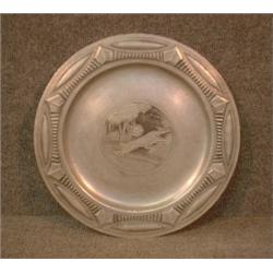 Un plat Art Deco en étain décoré d'une paire de lévriers dans un encadrement géométrique....