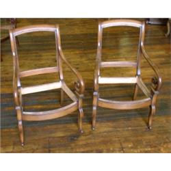 Une paire de fauteuils en acajou de style Charles X, les accoudoirs à enroulement, sur des pieds...