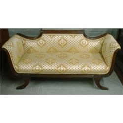 Un canapé en acajou, le dossier découpé, la ceinture et les pieds arqués cannelés....